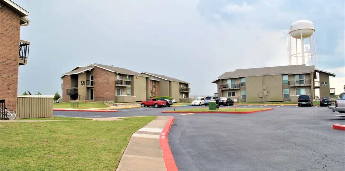 Westwood Manor two-story apartment complex with brick accents and parking area in Howe, Texas